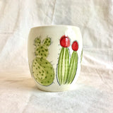 Handmade pottery mug with a hand painted cactus and succulent design pattern.