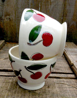Two coffee cozy bowls handmade and handtrown made of porcelain with cherries pattern
