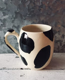 The cowboy mug with cow patterns made of hand-turned porcelain clay