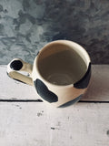 The cowboy mug with cow patterns made of hand-turned porcelain clay